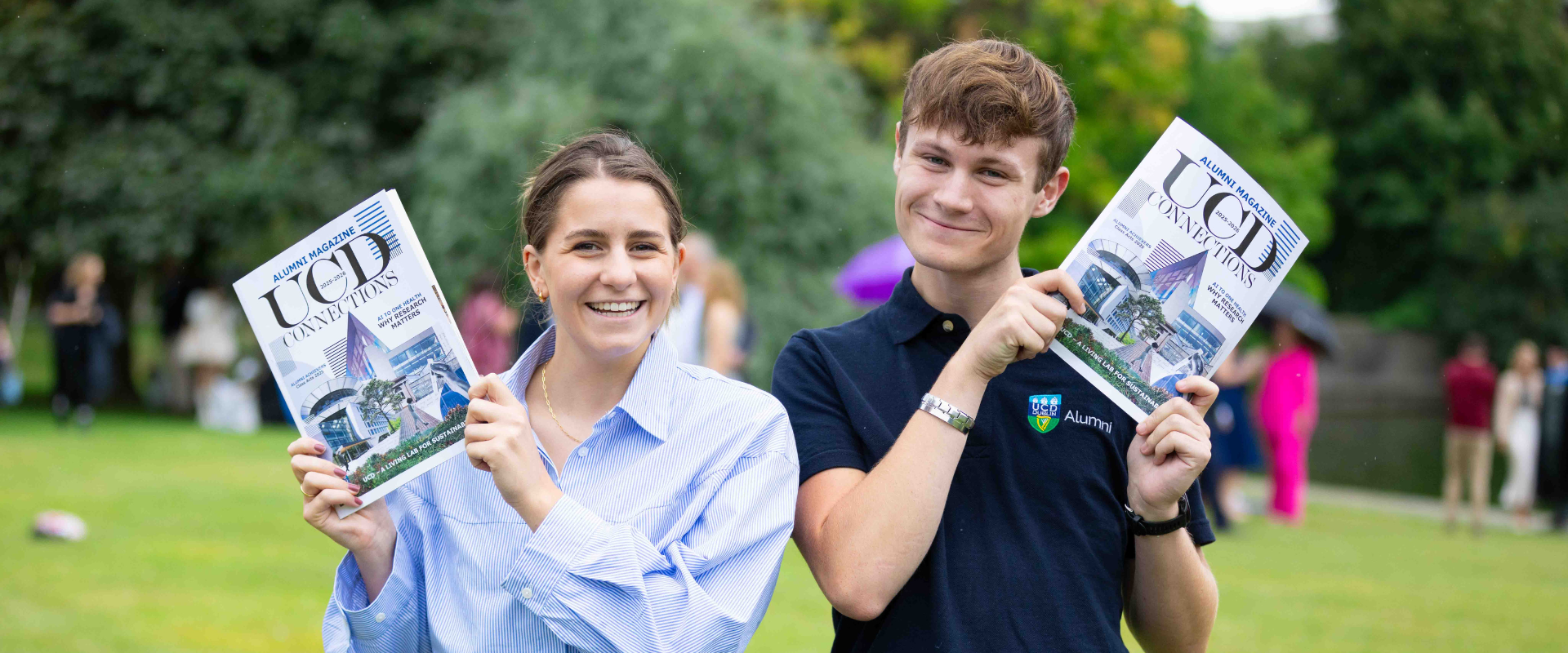 Two UCD alumni holding up copies of UCD Connections 2025, the annual alumni magazine.